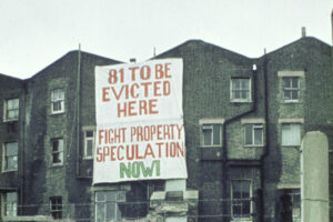 Banner displayed on the back of the south side of Tolmers Square facing Euston Road, 1975